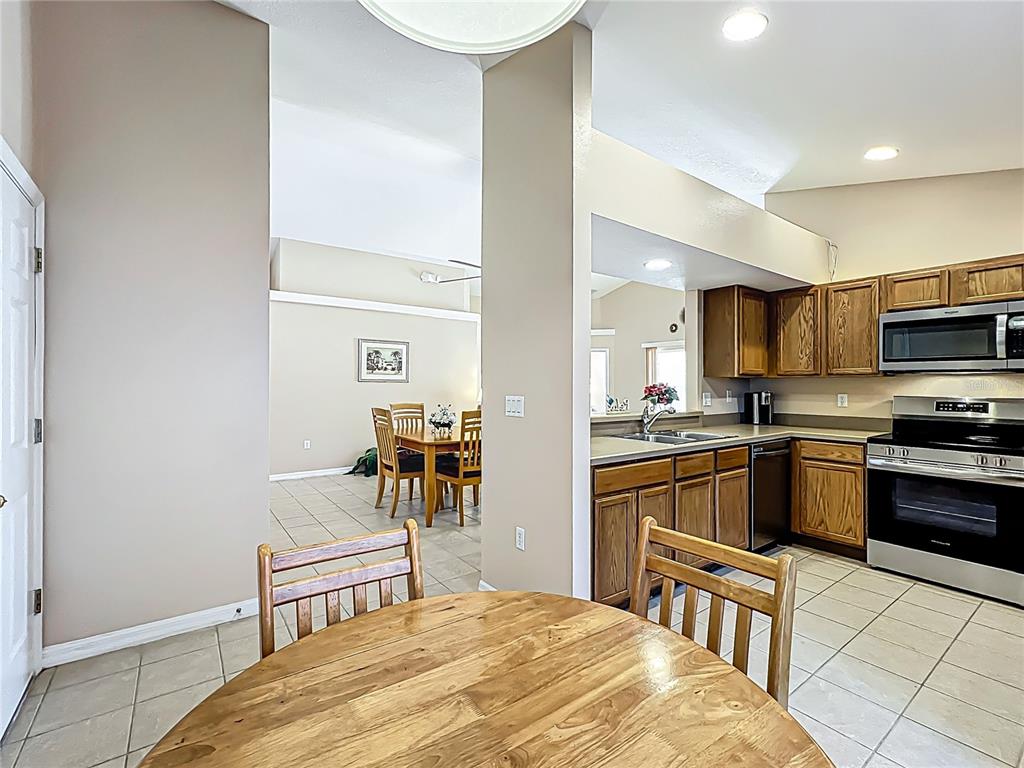 420 Robin Road Davenport, FL 33896 - Photo 13 of 29 a kitchen with granite countertop a sink cabinets stainless steel appliances and a dining table