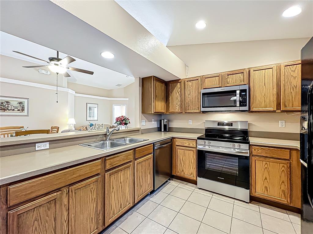 420 Robin Road Davenport, FL 33896 - Photo 14 of 29 a kitchen with stainless steel appliances granite countertop a sink and cabinets