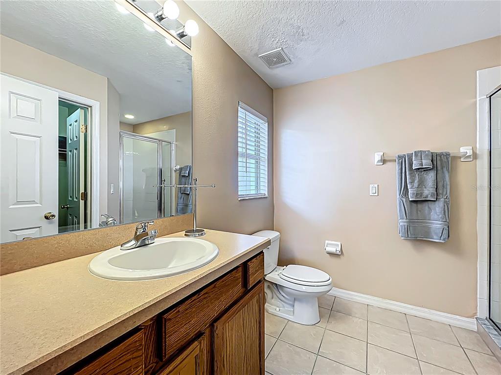 420 Robin Road Davenport, FL 33896 - Photo 20 of 29 a bathroom with a sink a toilet a shower and a mirror