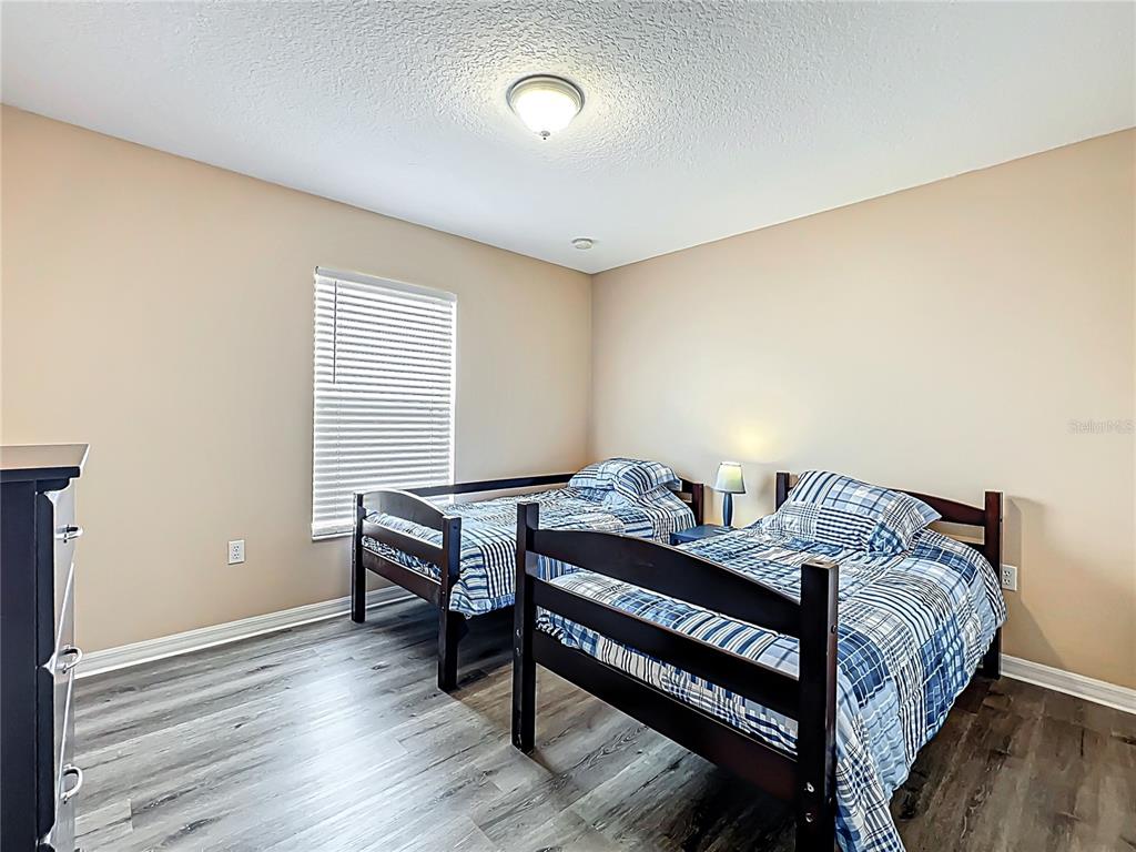 420 Robin Road Davenport, FL 33896 - Photo 24 of 29 a bedroom with a bed and wooden floor