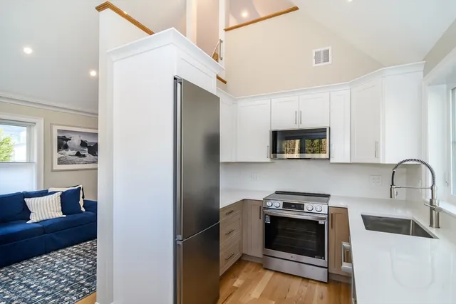 a kitchen with stainless steel appliances granite countertop a refrigerator and a stove top oven