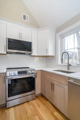a kitchen with stainless steel appliances a stove a microwave a sink and cabinets