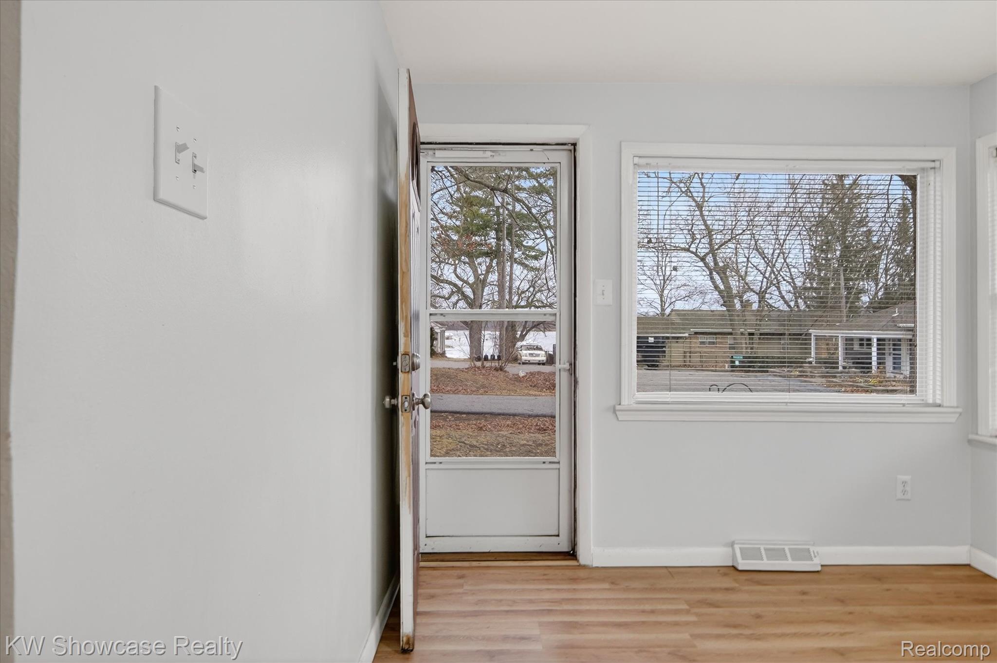 1860 Ladd Road Walled Lake, MI 48390 - Photo 9 of 48 Doorway to outside featuring wood finished floors and baseboards