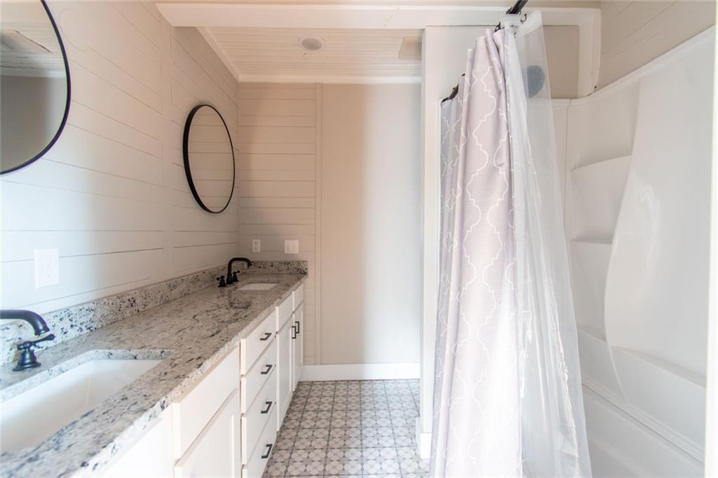 702 Radford Street Monroe, GA 30655 - Photo 36 of 49 a bathroom with a granite countertop sink and a mirror