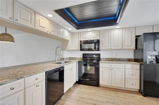 a kitchen with stainless steel appliances granite countertop a sink and dishwasher a stove top oven with wooden floor