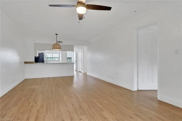 a view of empty room with wooden floor