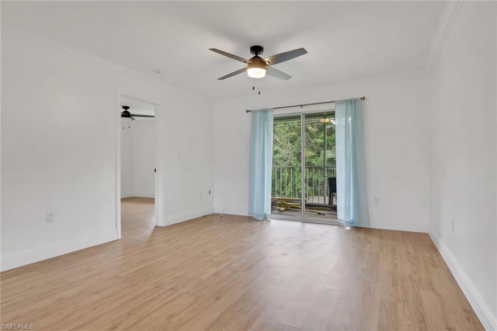 146 Cypress Way East, Unit 7 Naples, FL 34110 - Photo 12 of 27 a view of an empty room with wooden floor and a window