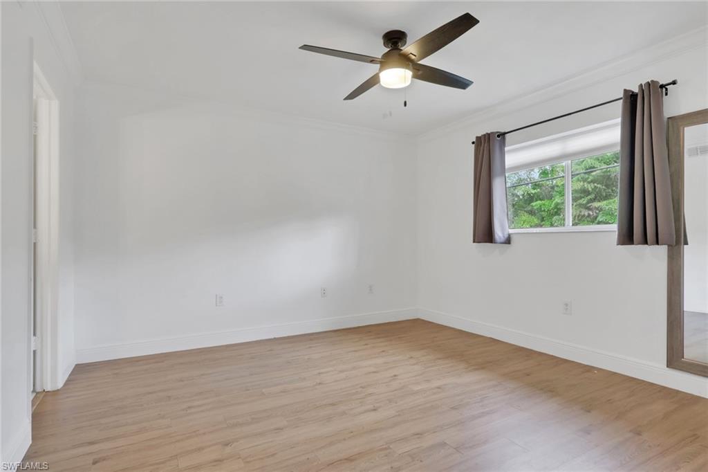 146 Cypress Way East, Unit 7 Naples, FL 34110 - Photo 14 of 27 wooden floor in an empty room with a window
