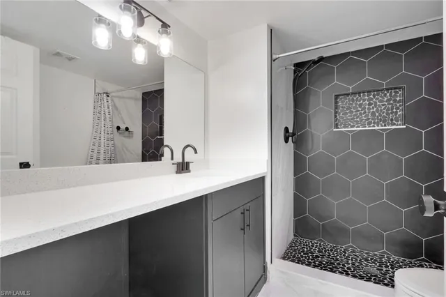 a bathroom with a sink a mirror a vanity and a shower