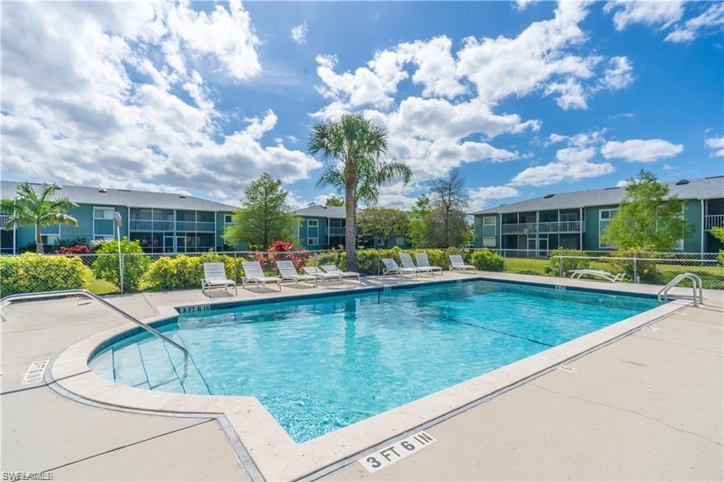 146 Cypress Way East, Unit 7 Naples, FL 34110 - Photo 25 of 27 a view of a swimming pool and lounge chair