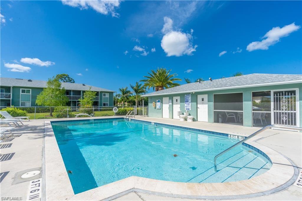 146 Cypress Way East, Unit 7 Naples, FL 34110 - Photo 26 of 27 a view of a house with a swimming pool