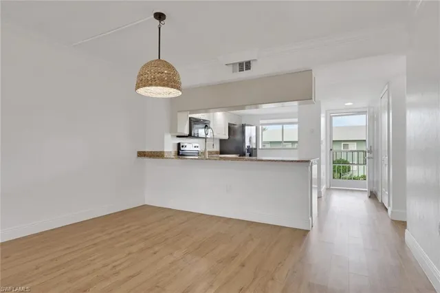 a view of a kitchen with wooden floor and a window