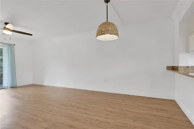 a view of a room with wooden floor and ceiling fan