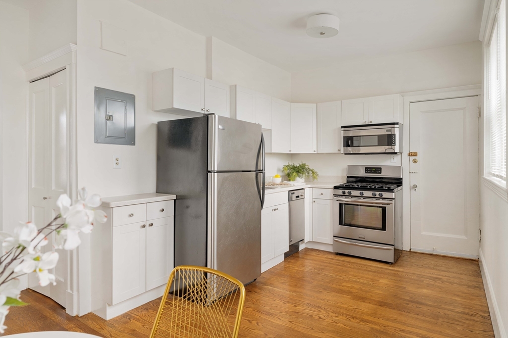 429 Washington Street, Unit 6 Brookline, MA 02446 - Photo 9 of 18 a kitchen with granite countertop a refrigerator and a stove top oven