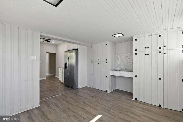 a view of a hallway with wooden floor and closet area