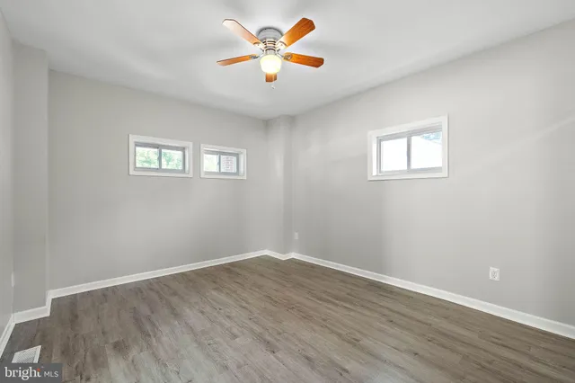 a view of a room with wooden floor and a ceiling fan