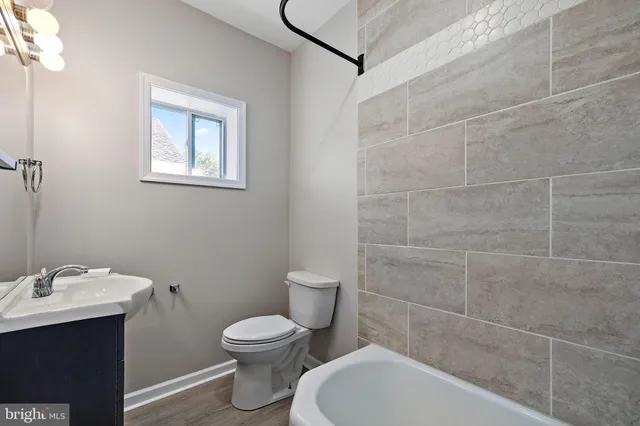 a bathroom with a toilet a sink and mirror