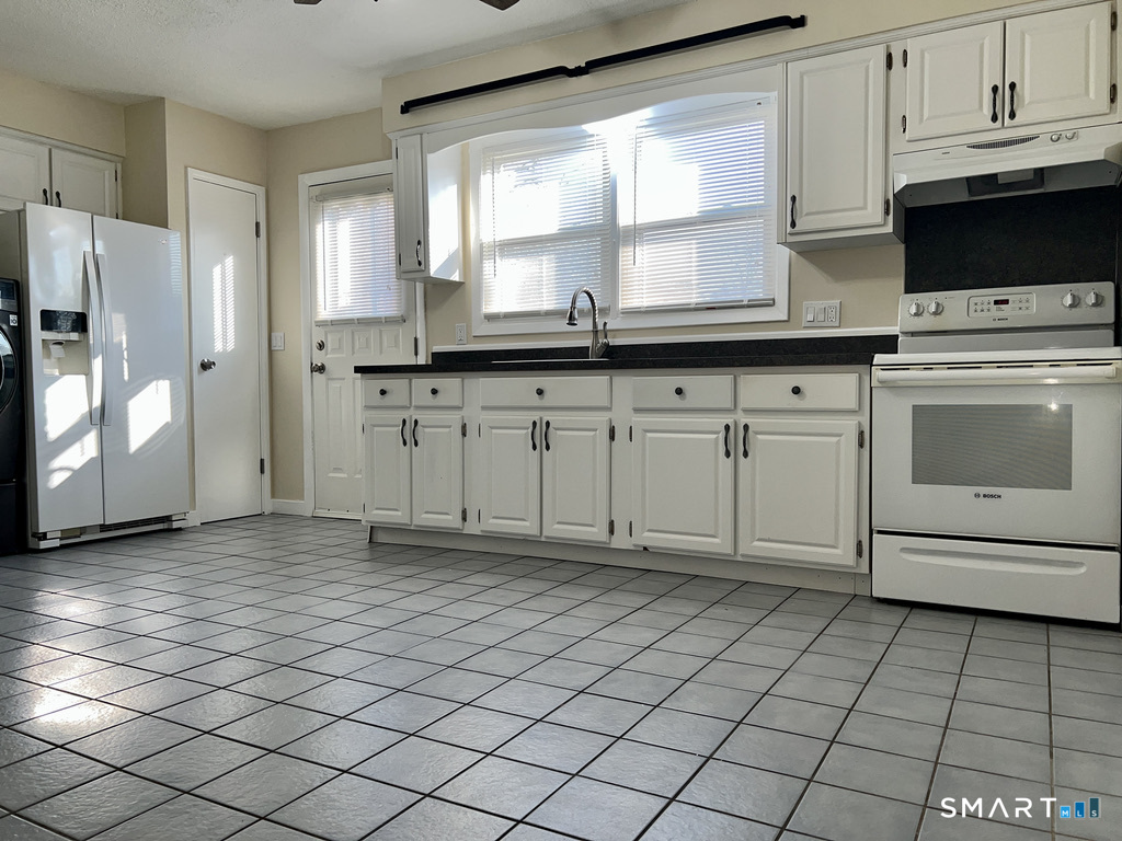 8 Roma Street, Unit 8 East Haven, CT 06512 - Photo 7 of 26 a kitchen with granite countertop a stove a sink and a refrigerator