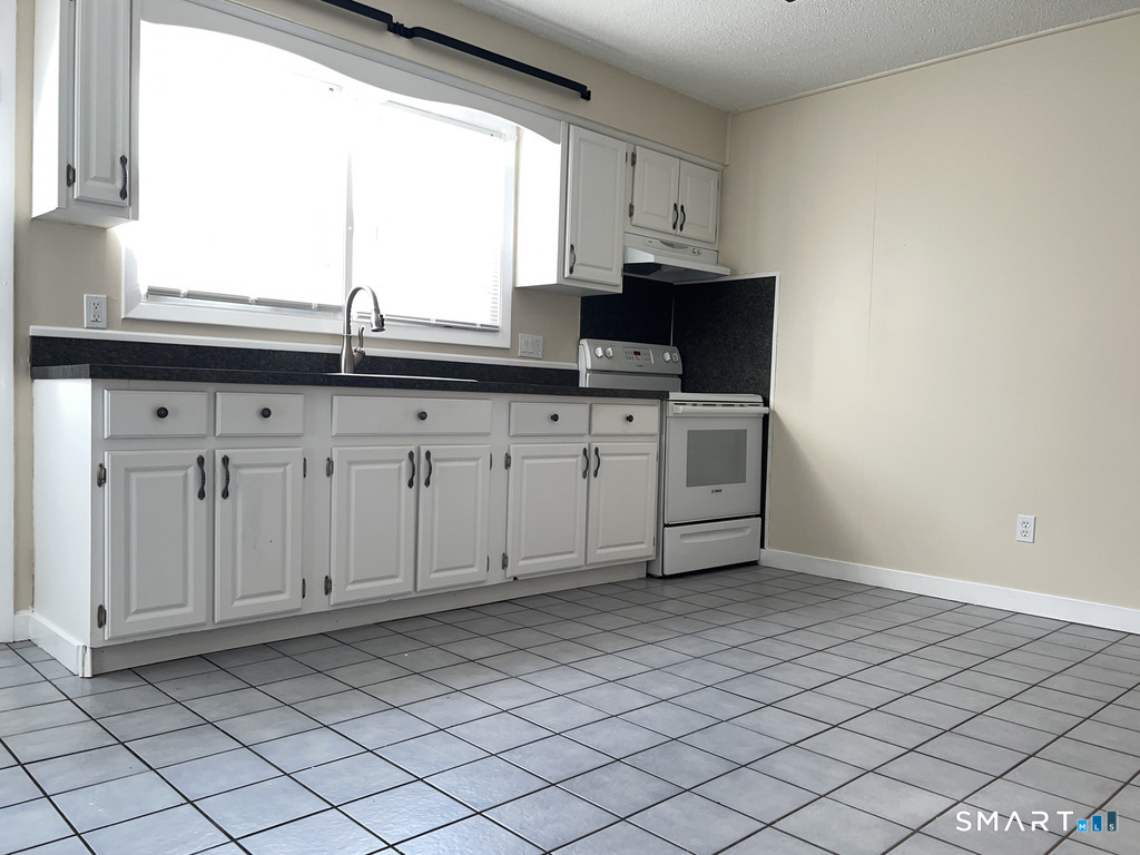8 Roma Street, Unit 8 East Haven, CT 06512 - Photo 8 of 26 a kitchen with stainless steel appliances granite countertop a sink and a window