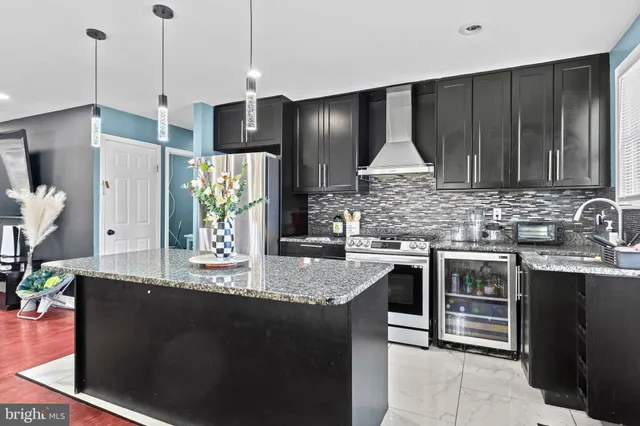 a kitchen with kitchen island granite countertop a sink stainless steel appliances and cabinets