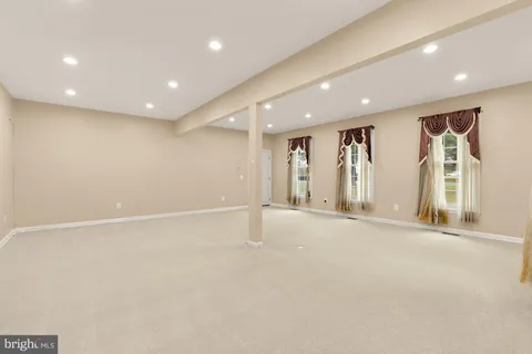 a view of empty room with windows and ceiling fan