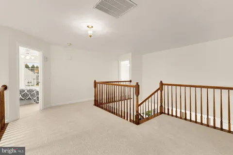 an empty room with windows and ceiling fan