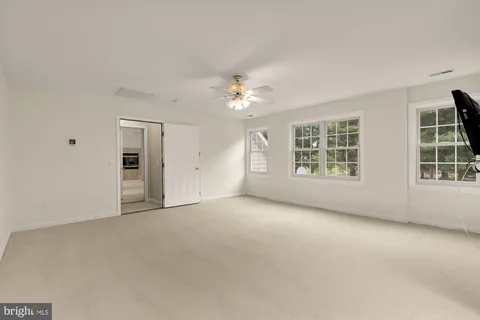 a living room with furniture two window and a wooden floor