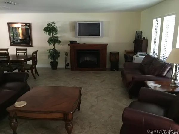 a living room with furniture a piano and a window