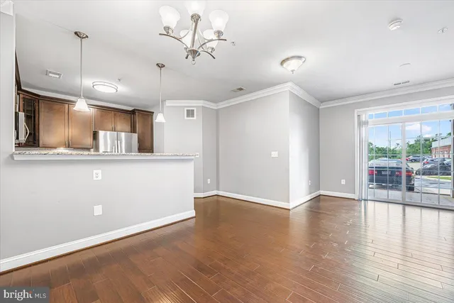 a view of kitchen with refrigerator stove and wooden floor