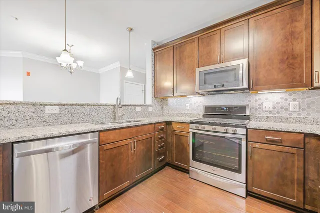 a kitchen with stainless steel appliances granite countertop a sink stove and microwave