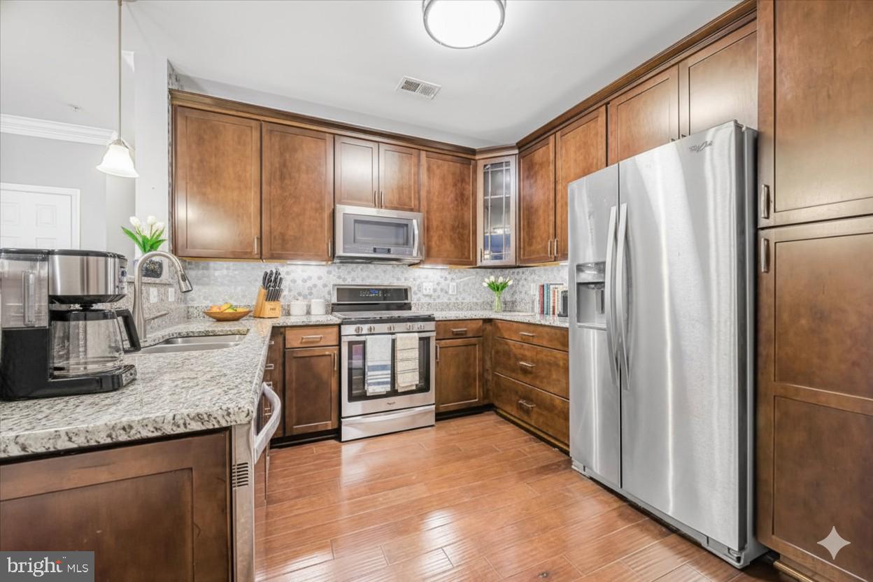 3911 Doc Berlin Drive, Unit 14 Silver Spring, MD 20906 - Photo 14 of 33 a kitchen with granite countertop a refrigerator stove top oven a sink and dishwasher