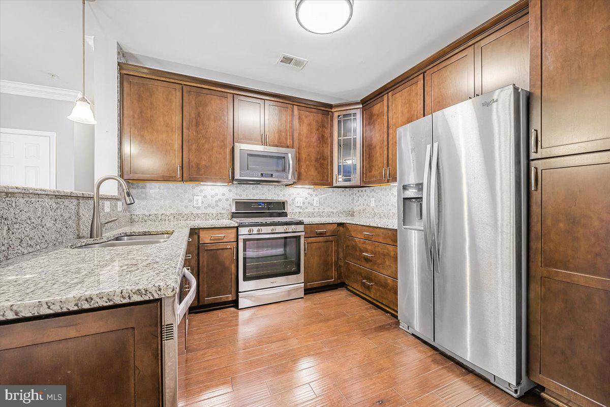 3911 Doc Berlin Drive, Unit 14 Silver Spring, MD 20906 - Photo 15 of 33 a kitchen with granite countertop a refrigerator stove and sink