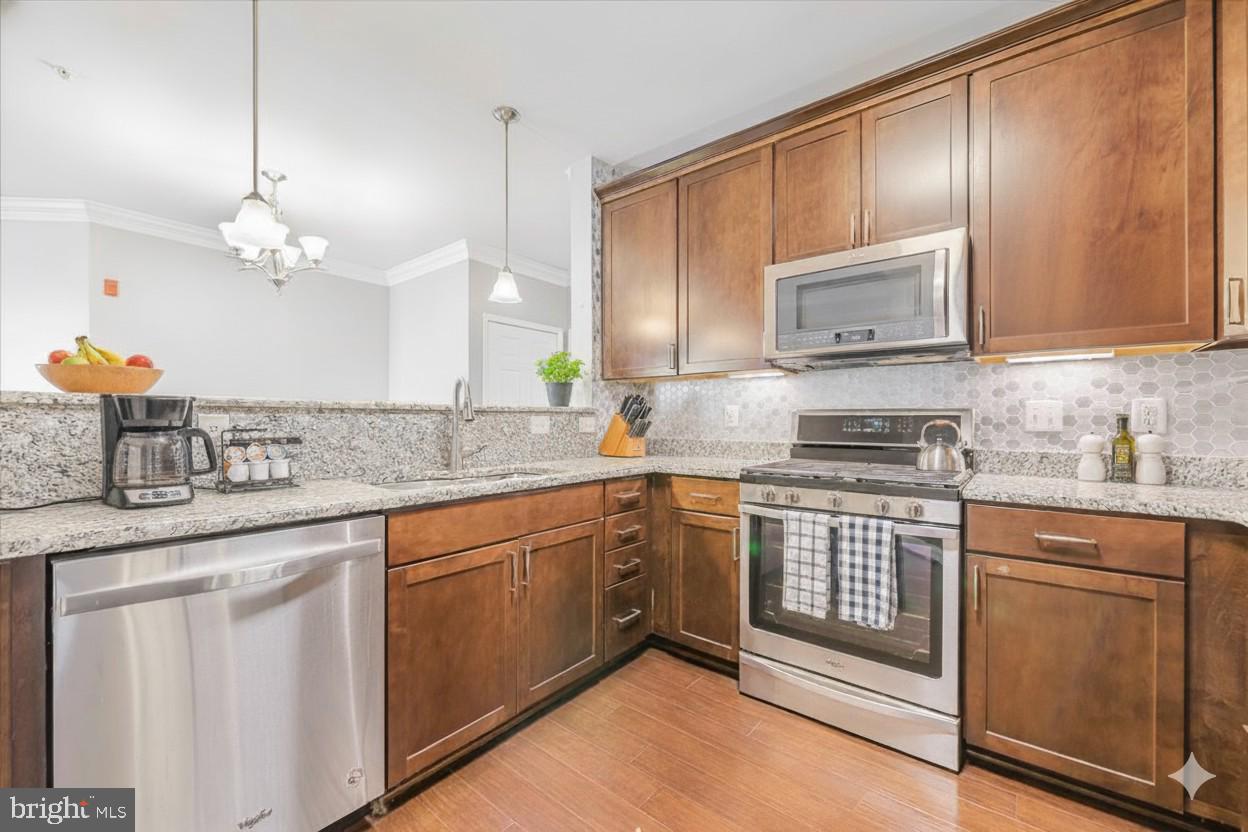 3911 Doc Berlin Drive, Unit 14 Silver Spring, MD 20906 - Photo 16 of 33 a kitchen with stainless steel appliances granite countertop a sink stove and microwave