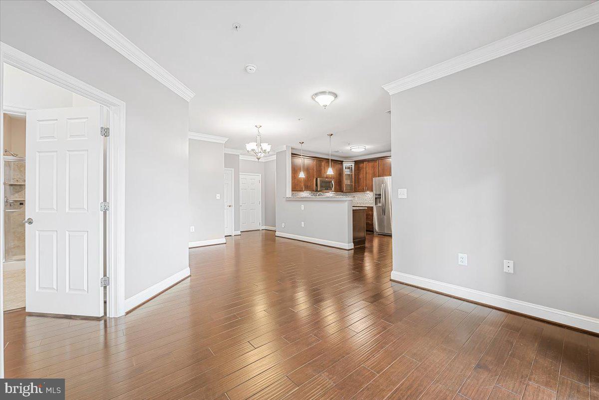 3911 Doc Berlin Drive, Unit 14 Silver Spring, MD 20906 - Photo 8 of 33 an empty room with wooden floor and a kitchen