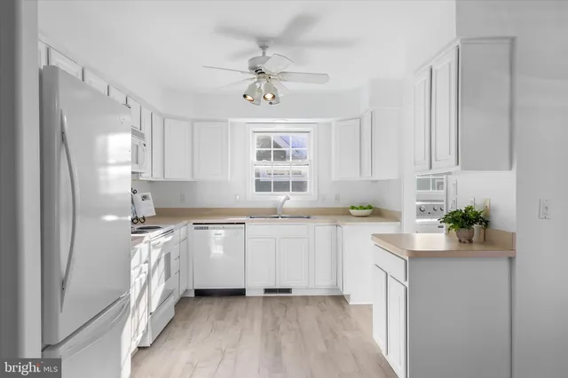 a view of a kitchen with wooden floor and windows