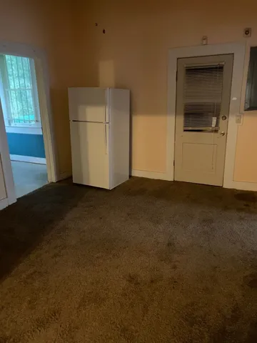 a view of an empty room with a kitchen