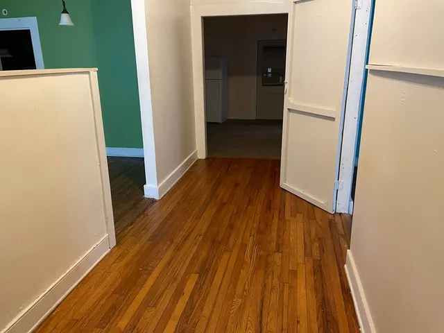 a view of a hallway with wooden floor