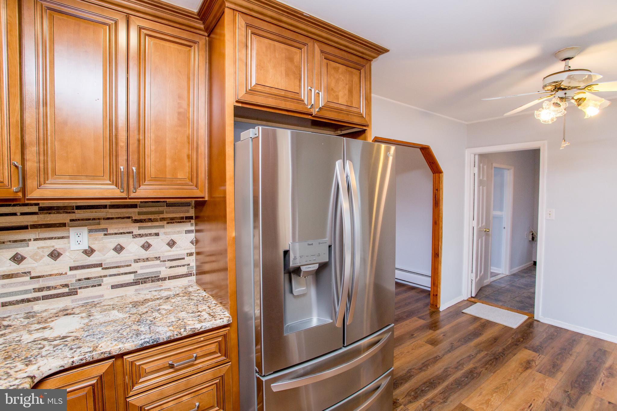 23 Misty Pine Road Levittown, PA 19056 - Photo 15 of 74 a view of a refrigerator a mirror and cabinets in a kitchen