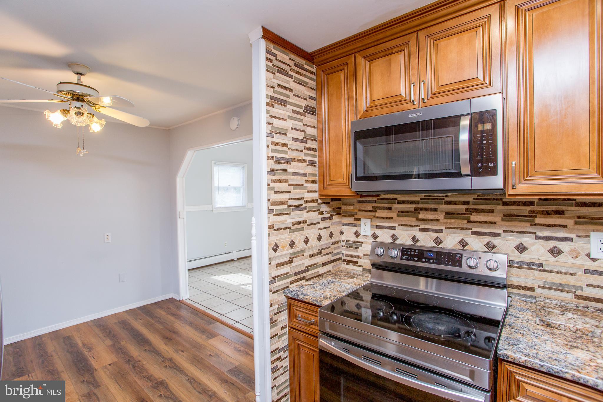 23 Misty Pine Road Levittown, PA 19056 - Photo 17 of 74 a kitchen with wooden cabinets and a stove top oven