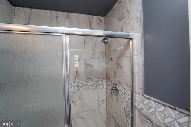 a view of a backyard with plants and large trees with wooden fence