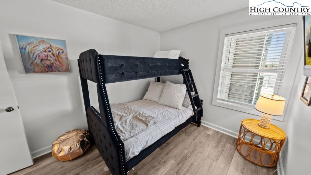 301 Pinnacle Inn Road, Unit 1114 Beech Mountain, NC 28604 - Photo 14 of 16 a bedroom with a bed and wooden floor
