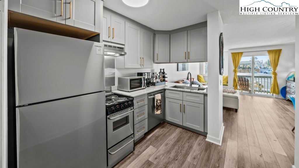 301 Pinnacle Inn Road, Unit 1114 Beech Mountain, NC 28604 - Photo 9 of 16 a kitchen with stainless steel appliances a refrigerator stove and sink