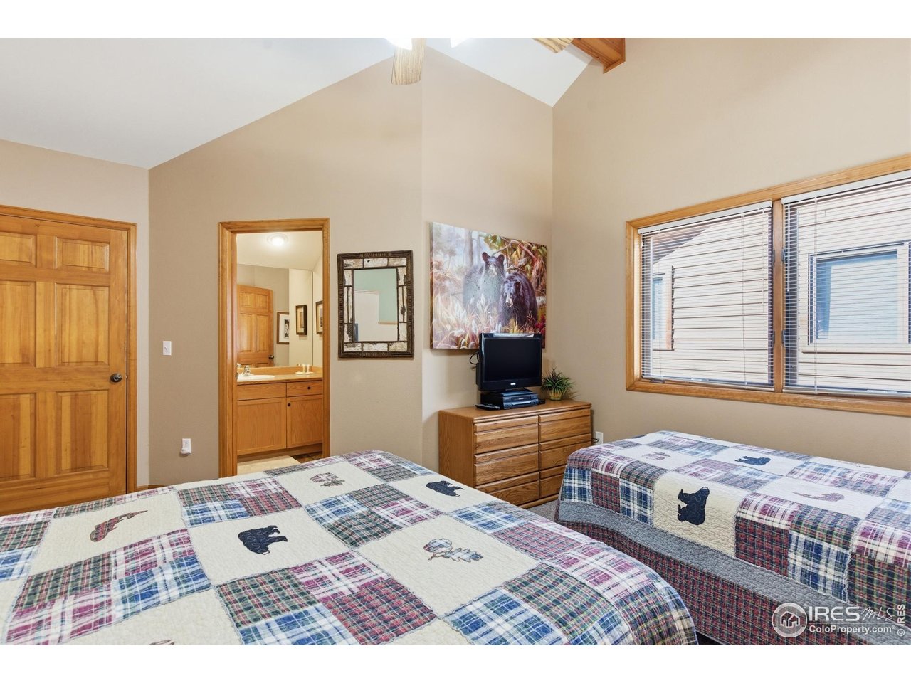 2120 Fall River Road, Unit 2 Estes Park, CO 80517 - Photo 20 of 28 a bedroom with a bed dresser and a flat screen tv