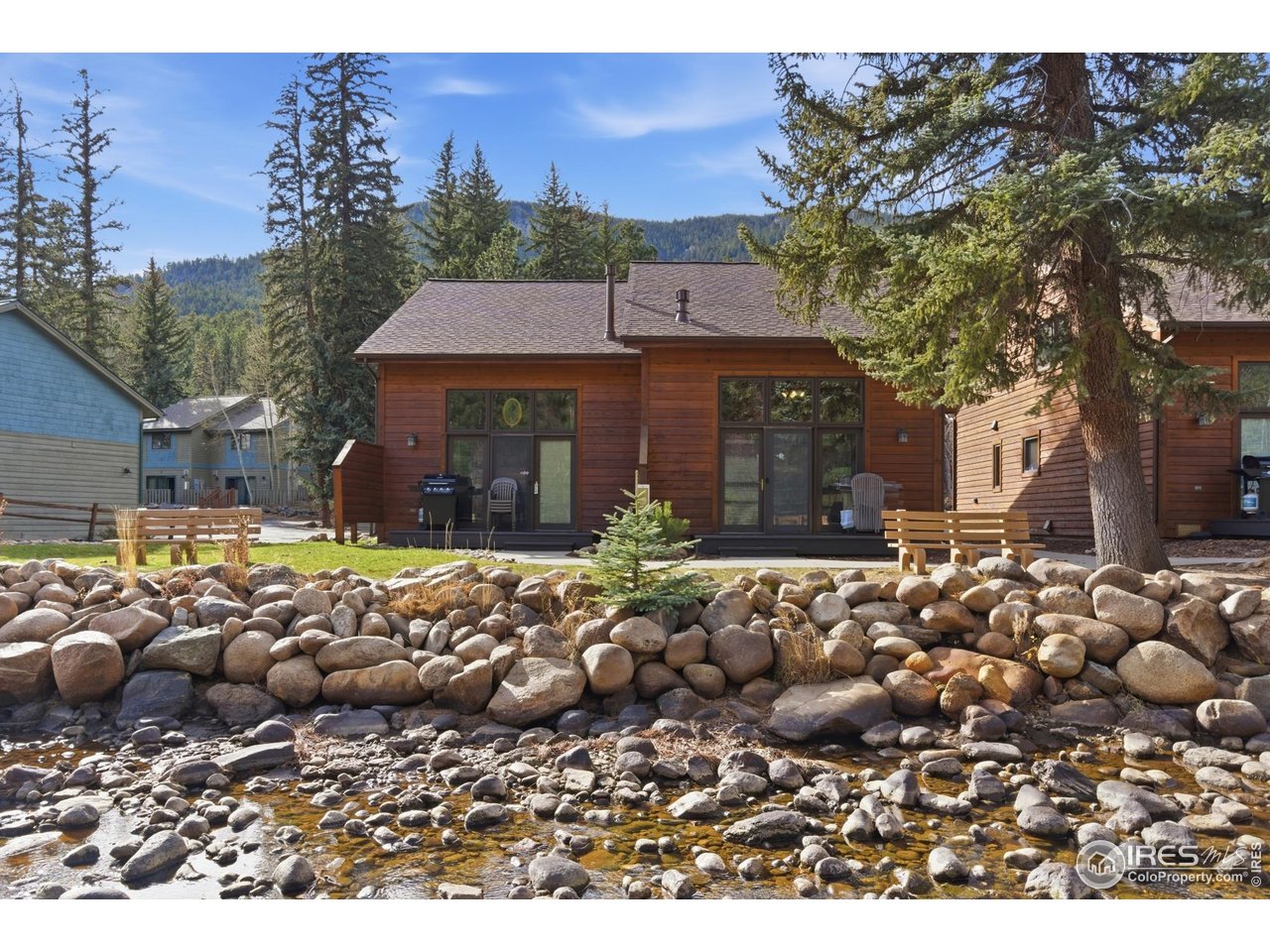 2120 Fall River Road, Unit 2 Estes Park, CO 80517 - Photo 26 of 28 a view of a house with a yard fire pit and large tree