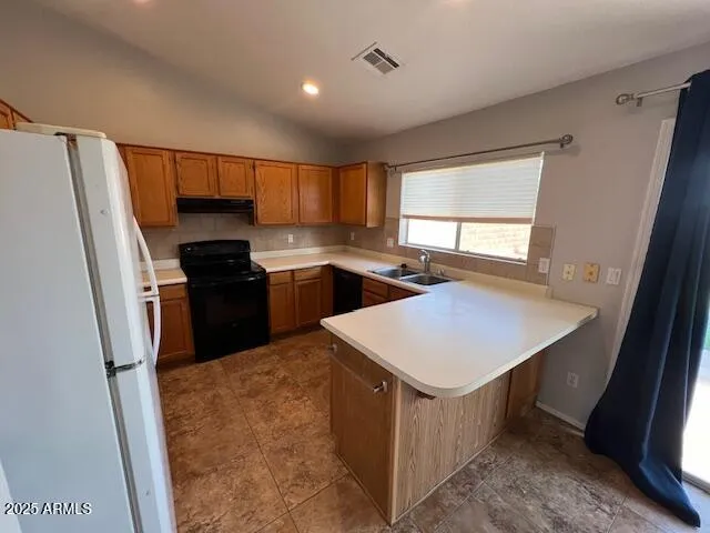 a kitchen that has a sink stainless steel appliances a window and a counter top space