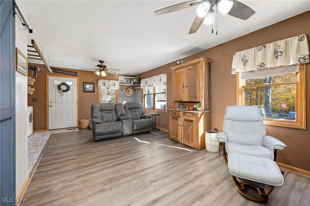 11827 Stratton Road West Salem, OH 44287 - Photo 25 of 47 Living room featuring a ceiling fan, light wood-style flooring, and washer / dryer