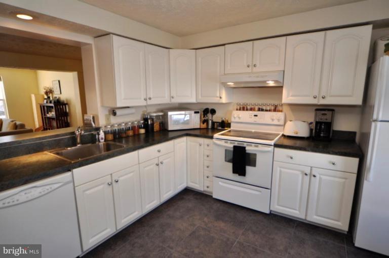 1491 Autumn Ridge Circle Reston, VA 20194 - Photo 5 of 20 a kitchen with white cabinets and white appliances