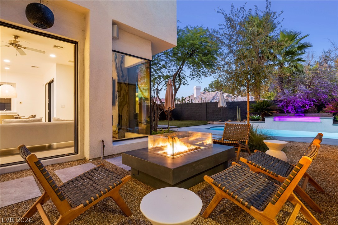 2000 Grouse Street Las Vegas, NV 89134 - Photo 2 of 89 An inviting outdoor living space features a modern fire pit and serene pool, perfect for twilight gatherings.