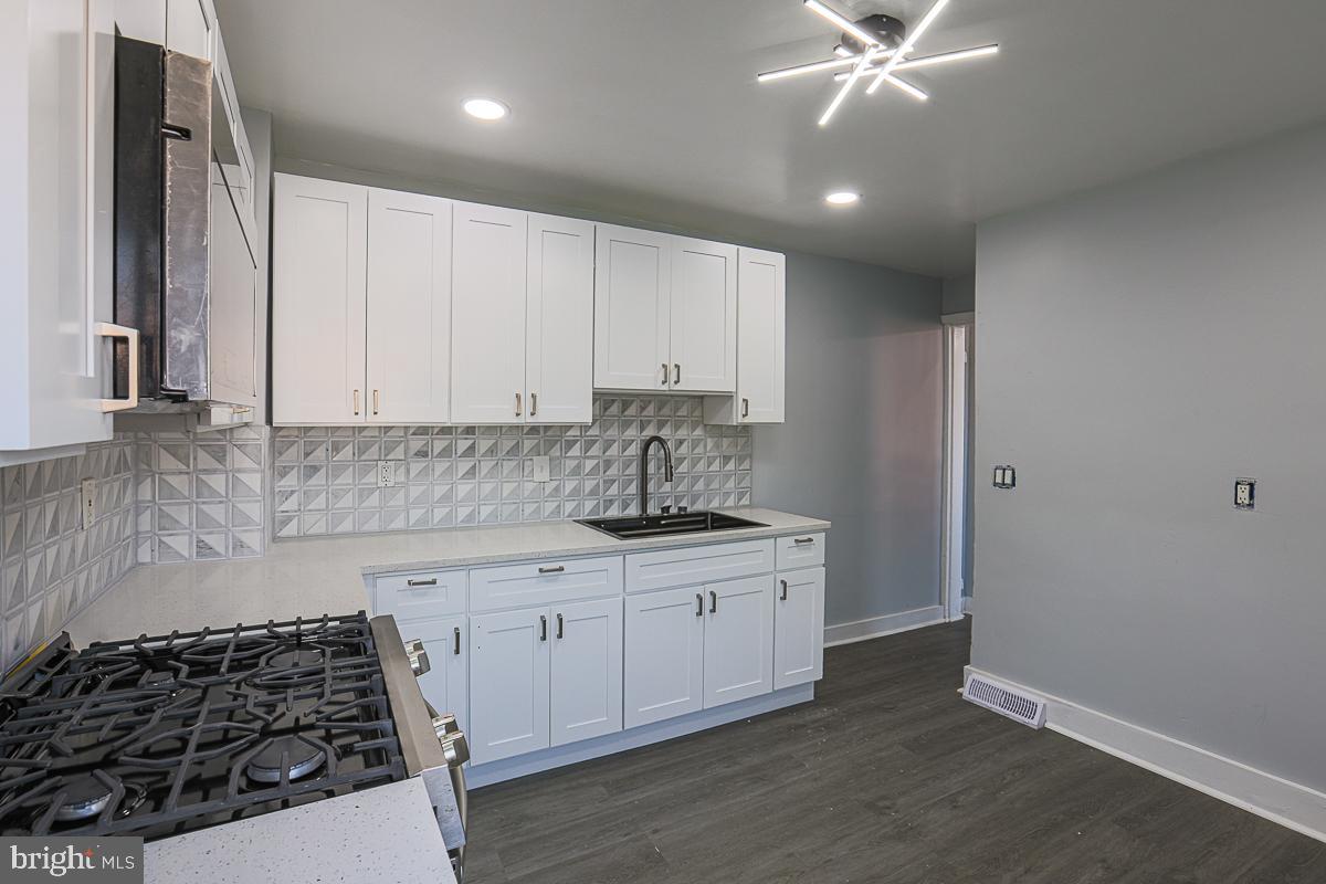 604 East 31st Street Baltimore, MD 21218 - Photo 29 of 50 a kitchen with sink a stove and cabinets