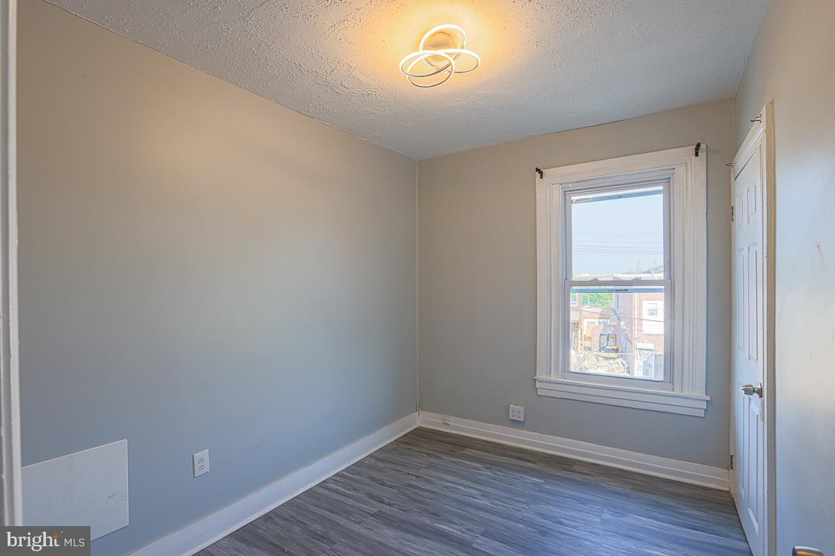 604 East 31st Street Baltimore, MD 21218 - Photo 36 of 50 a view of an empty room with wooden floor and a window